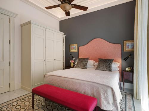 a bedroom with a bed with a pink headboard and a red bench at Hotel Gloria de Sant Jaume in Palma de Mallorca