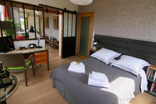 a bedroom with a bed with two towels on it at bibou's room Paris in Les Lilas