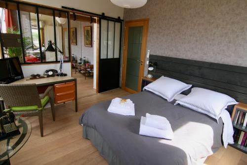 sypialnia z łóżkiem z dwoma ręcznikami w obiekcie bibou's room Paris w mieście Les Lilas