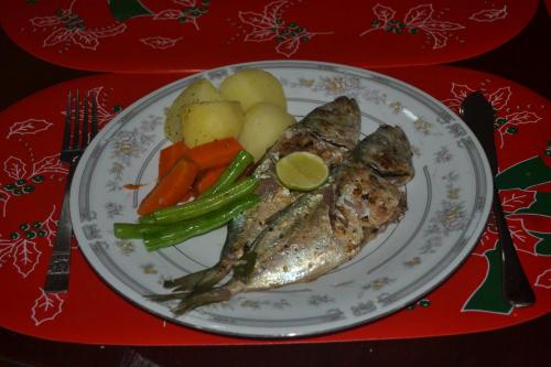 a plate of fish and vegetables on a red tray at Kuma Beach side Villa in Wadduwa
