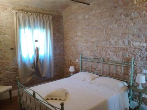 1 dormitorio con cama y ventana en Podere Le Volte degli Angeli en Spello