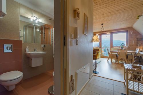ein Bad mit einem WC und einem Waschbecken sowie ein Esszimmer in der Unterkunft Apartament KROKUS in Kościelisko
