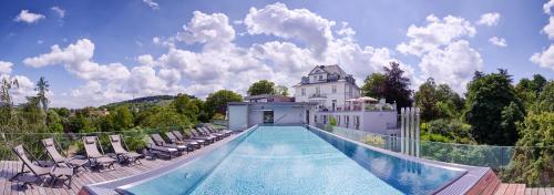 - une piscine avec des chaises et une maison dans l'établissement Hotel Villa Hügel, à Trèves