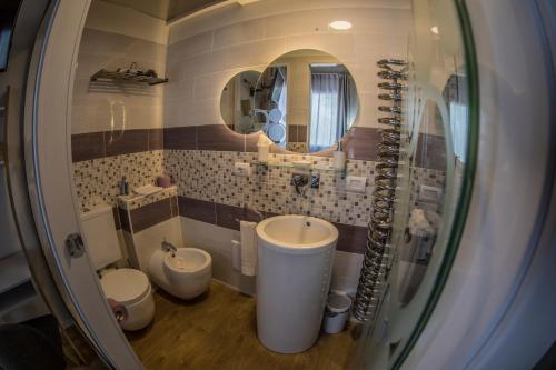 a bathroom with two toilets and a sink and a mirror at A casa di V-Ale in Treviso