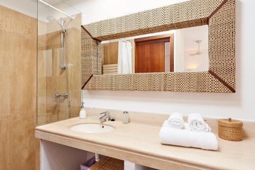 a bathroom with a sink and a mirror at Can Mares in Cala Tarida