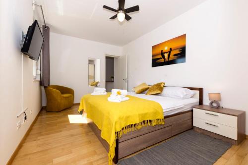 a bedroom with a bed with a yellow blanket on it at Cvit Jadrana in Split