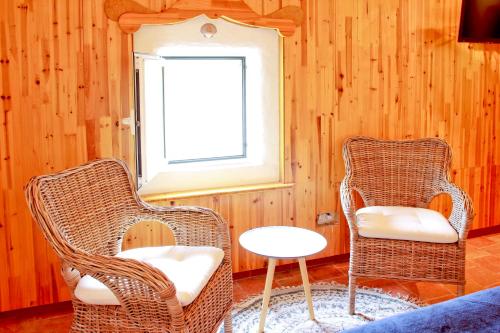 two wicker chairs and a table in a room at Habitaciones Casa de Campo Daymipaz in Mahón