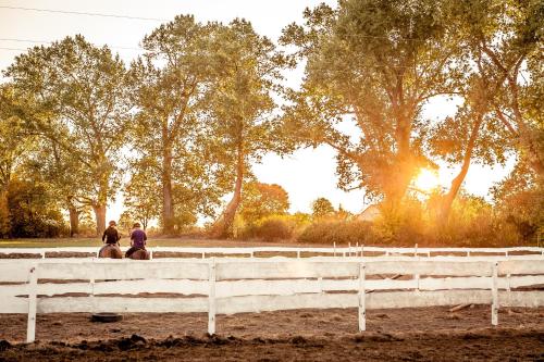 two people riding on a horse in front of a fence at Hotel&SPA Dwór Droblin in Leśna Podlaska