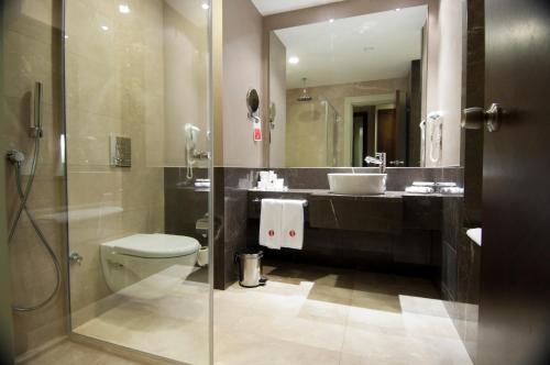 a bathroom with a toilet and a sink and a shower at Ramada Plaza Antalya in Antalya