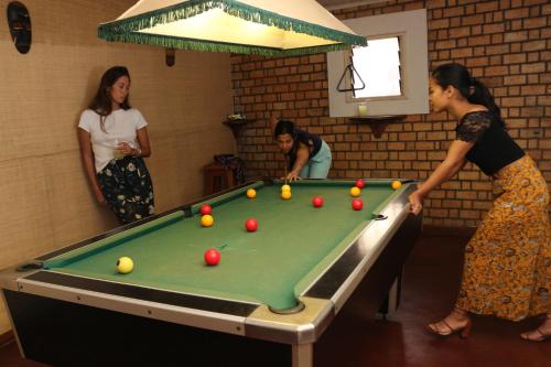a group of women standing around a pool table at Hotel Mahavelo in Antananarivo