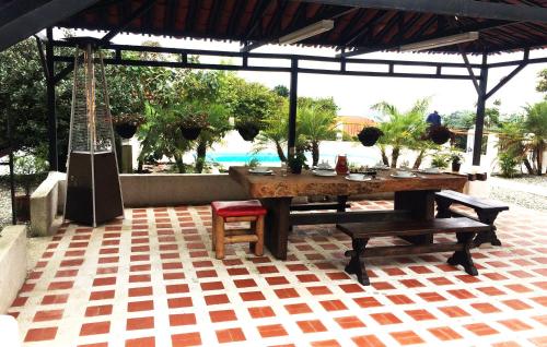a table and chairs on a patio with a guitar at Finca Campestre La Adelita B&B in Salento