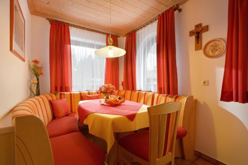 un comedor con una mesa y una cruz en la pared en Appartement Jöchl en Ellmau