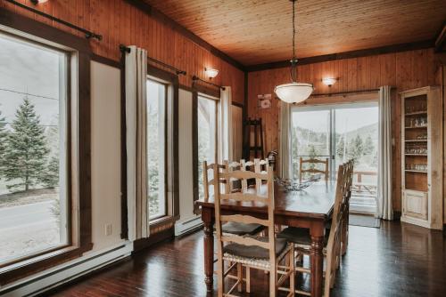 a dining room with a table and chairs and windows at Royal Laurentien in Mont-Blanc