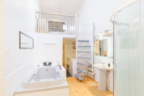 a bathroom with a tub and a sink and a staircase at Quebec Grand Appartement by Hébergements DCL in Quebec City