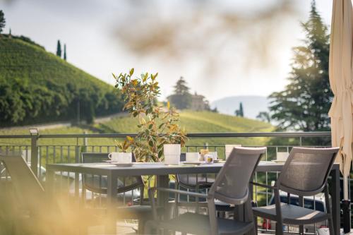 a table and chairs with a view of a field at Vineus Tramin in Termeno