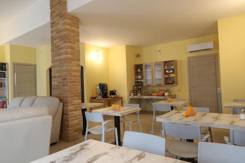 a living room with a couch and tables and a kitchen at BorgoPratole CountryHouse in Cingoli
