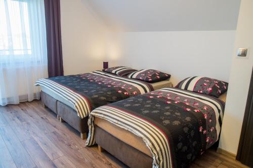 a room with two beds with blankets on them at Villa Mikołajki Popiełuszki 8 in Mikołajki