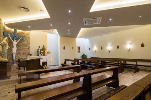 a church with a row of wooden pews and a stage at Medjugorje Hotel & Spa in Međugorje
