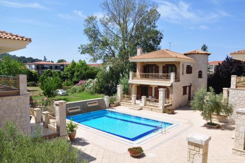 a villa with a swimming pool and a house at Anastasia Villas in Siviri