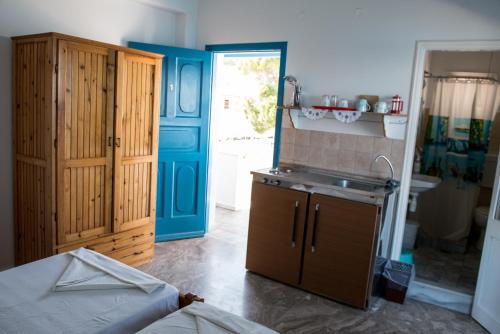 a kitchen with a sink and a blue door at Avra Studios in Myrties