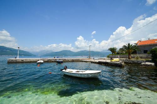 a small boat in the water near a dock at Leut Stone Residence in Tivat