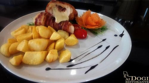 a plate of food with meat and fruit on it at Medjugorje Hotel & Spa in Međugorje