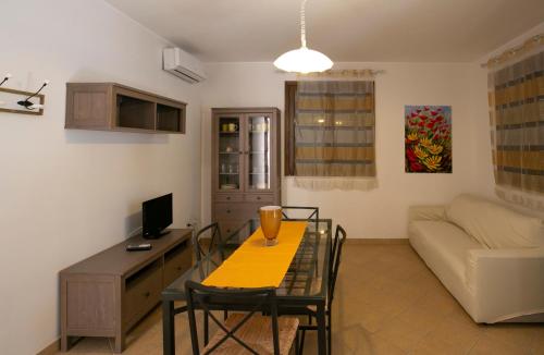 a living room with a table and a couch at Boa Vista San Vito - Area Fitness, Barbecue Area, Tennis Court in San Vito lo Capo