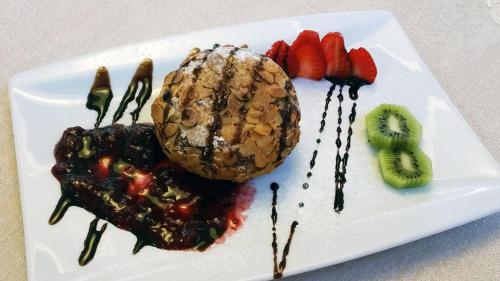 a plate of food with fruit and chocolate sauce at Medjugorje Hotel & Spa in Međugorje