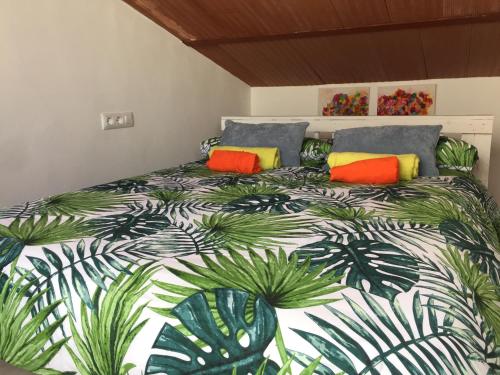 una camera da letto con un grande letto con cuscini colorati di Ático. Centro. Penthouse a Granada