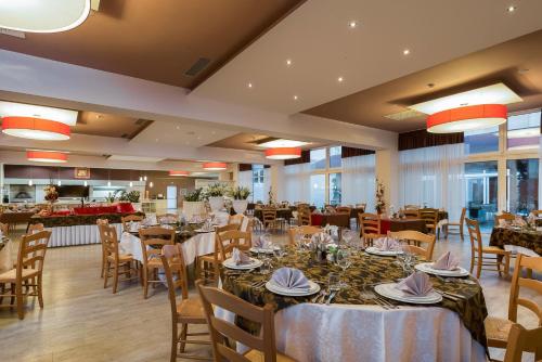 a dining room with tables and chairs in a restaurant at Medjugorje Hotel & Spa in Međugorje