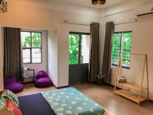 a bedroom with a bed and some windows at Duy Tan Home in Quy Nhon