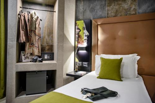 a hotel room with a bed with a green pillow at Just Hotel Milano in Milan
