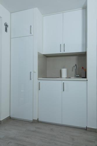 a kitchen with white cabinets and a sink at The Little Prince in Lopud Island