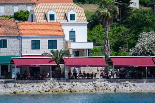 a restaurant with red awnings next to the water at The Little Prince in Lopud Island