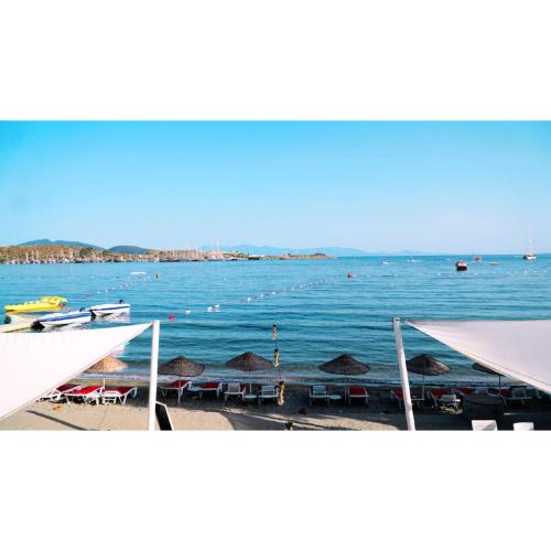 a view of a beach with umbrellas and the water at Gumbet Cove Hotel in Gümbet
