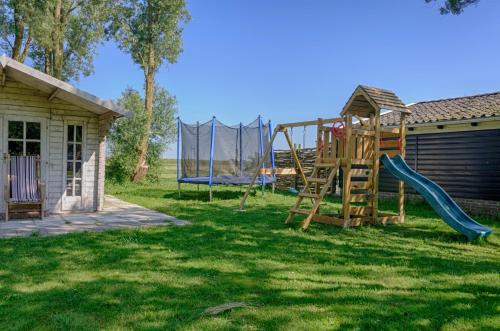 een tuin met een glijbaan en een speeltuin bij Traphoeve in Schagen