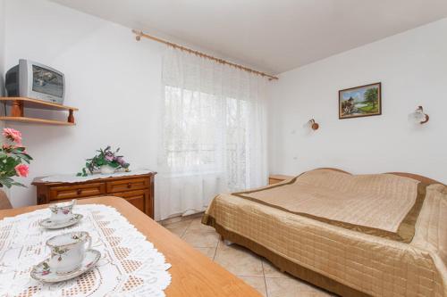 a bedroom with a bed and a table and a television at Willa Nova - 4 minuty od plazy in Pobierowo