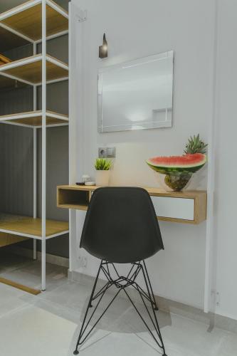 a desk with a black chair in a room at Hotel Papagalos in Neos Marmaras