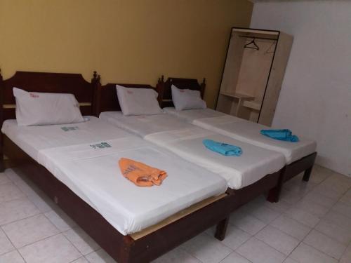 2 Einzelbetten in einem Zimmer mit Handtüchern darauf in der Unterkunft Bee Hub Pension in Surigao