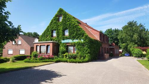una casa con hiedra creciendo a su lado en Gästehaus Zur alten Post, en Dornumersiel