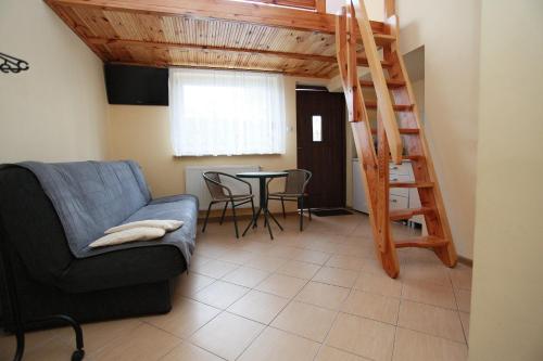 salon ze schodami, kanapą i stołem w obiekcie Słoneczne Apartamenty w mieście Mielno