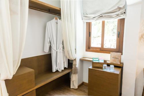 a dressing room with a robe and a window at Hostal La Torre Ibiza Cap Negret in San Antonio