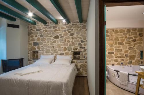 a bedroom with a bed and a bath tub at Hotel Arhontiko Vourloka in Pramanta