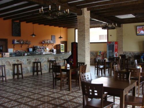 un restaurante con mesas y sillas y un bar en Apartamentos rurales Manolo, en Casas del Monte