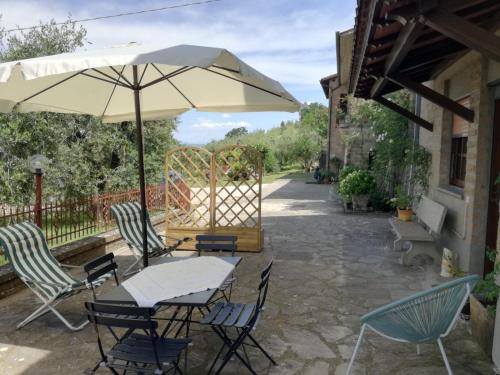 a table and chairs with an umbrella on a patio at Orvieto Rocca Fiorita in Orvieto