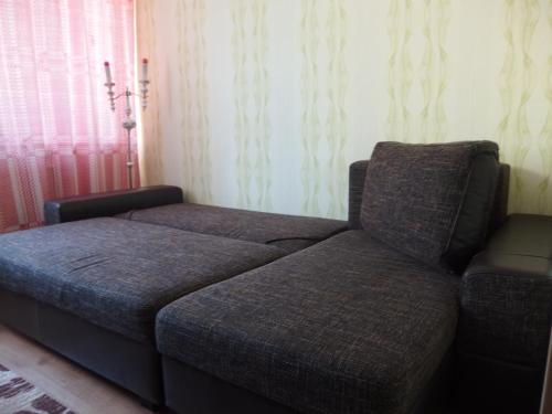 a bed and a couch in a room at Namas in Klaipėda