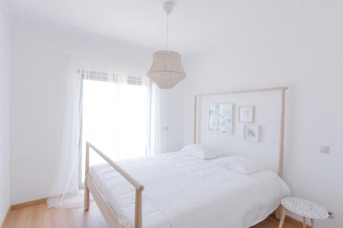オリョンにあるCasas de Mar - Barcoの白いベッドルーム(ベッド1台、窓付)