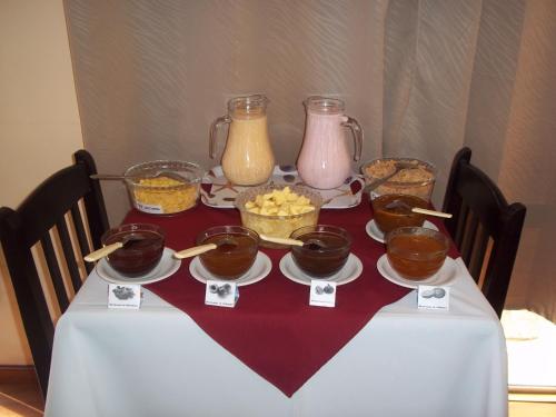 uma mesa coberta com tigelas de comida e frascos de mel em Brisas Del Rio Apart Hotel em Termas del Daymán