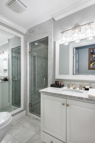 a white bathroom with a shower and a toilet at The Quarters on Vendue in Charleston