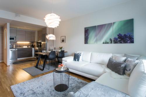 a living room with a white couch and a table at Vasko luxurious suites, Nouka in Rovaniemi